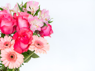 Bouquet of fresh pink roses, gerberas, and alstroemeria on a white background with copy space
