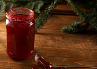 can with raspberry jam on a wooden background
