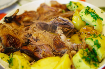 Oven-baked chopped duck stuffed with apples. Finished duck, cut and laid on a platter with potatoes.
