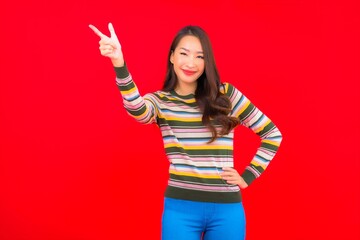 Portrait beautiful young asian woman smile with action on red background