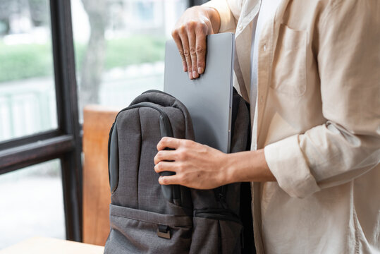 Man packing away his laptop into a bag