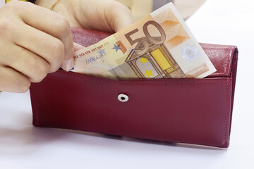 50 Euro bill in a woman's hand, red wallet