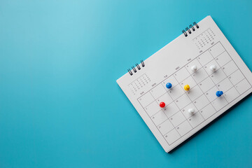 Calendar on solid ิblue background with copy space, pinned in a calender on datebusiness meeting schedule, travel planning or project milestone and reminder concept.