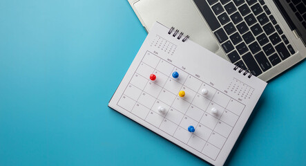 Calendar on solid ิblue background with copy space, pinned in a calender on datebusiness meeting schedule, travel planning or project milestone and reminder concept.