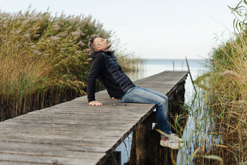 Man unwinding relaxing on a wooden jetty