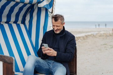 Man grinning as he reads a message on his mobile