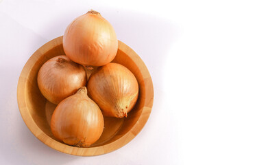 Large onion in a wooden bowl on a white background