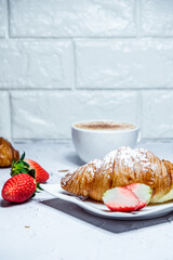 Continental breakfast with croissants. Coffee and fresh strawberries