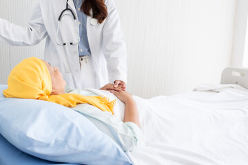 Friendly female doctor hands holding cancer patient hand laying on bed for encouragement, empathy, cheering and support while medical examination. Bad news lessening, compassion