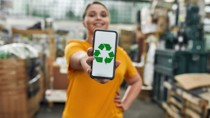 Selective focus on smartphone screen with recycling sign