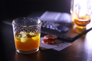 Gambling Card games for money. Texas Hold'em Poker. Cards in hand, playing chips, deck of cards of alcohol in a glass.