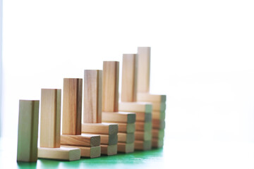 Stick wood block standing on stacked square wood blocks, abstract background in concept of winning, success, challenge, step to top position.