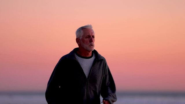 64 year old man getting his exercise at the beach at sunset. Slow Motion.