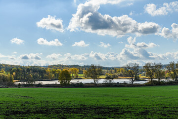 Obraz premium autumn view on empty pond near Sytno with trees and fields around