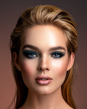 Photo of young woman with style make-up. Portrait of blonde woman with a beautiful face. Closeup face with stylish blue makeup. Fashion model with long hair, studio shot.