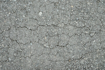 Old worn asphalt road with cracks texture