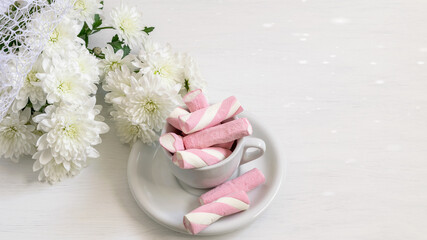 White chrysanthemums bouquet and marshmallows in the cup on the white background. Nice greeting card or party invitation. Valentines Day, Moms Day holidays concept.