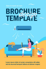 Woman sitting on sofa with cat and laptop under air conditioner