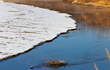 Landscape of a cold autumn river with snow outside the city.