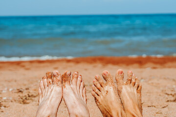 Fototapeta na wymiar couple feet on the beach by the sea