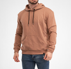 man wears beige hoodie. bearded young guy stands in khaki colored sweatshirt with hood. isolated catalogue shooting