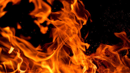 Fototapeta na wymiar Fire flames with sparks on a black background, close-up
