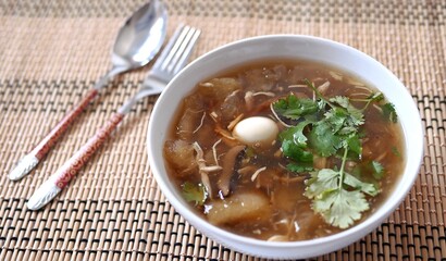 Braised  fish maw soup with chicken meat, quail egg and mushroom in deep bowl