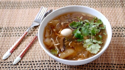 Braised  fish maw soup with chicken meat, quail egg and mushroom in deep bowl