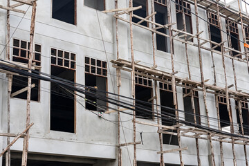 bamboo scaffolding in tall building construction - obrazy, fototapety, plakaty