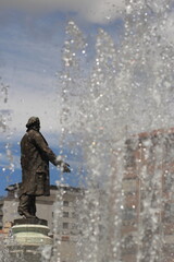 Statue in Valladolid next to palace, Spain, surrounded by jets of water from a fountain