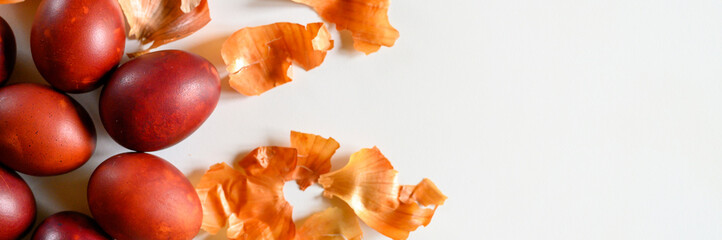 easter eggs painted onion husks on a white background. coloring the eggs according to the old natural eco-friendly method with peeled onions. space for text. banner