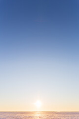 Vertical beautiful landscape, clear blue sky, low horizon, sunrise or sunset. Universal natural gradient background.