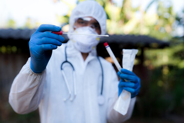 The doctors in the PPE protective suit performed a nasal congestion swab covid from a person to...