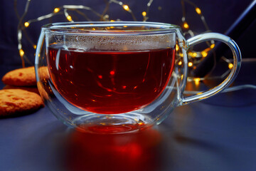Glass cup with tea on a dark background.