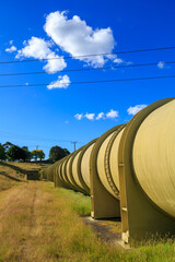 Obraz premium A giant metal water pipeline in the countryside (the water supply for a hydroelectric power station) 