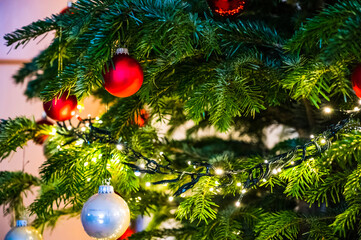 A closeup shot of a Christmas ball on a Christmas tree decorated with led lights