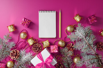 Fototapeta na wymiar Clean white notepad with pencil around Christmas decorations on pink background. Planning