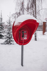 Red old pay phone in a winter park
