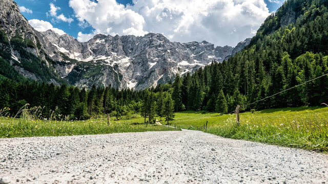 Surface level image of dirt road in beautiful valley in mountains. Zgornje Jezersko, Slovenia.