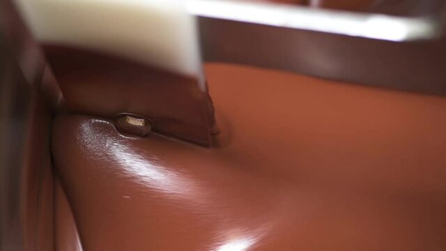 Liquid melted chocolate inside a chocolate conching machine. The machine grind the chocolate to smooth paste with friction and heat.