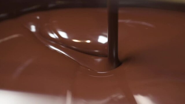 Melted smooth chocolate liquid inside a chocolate tempering machine. The temperature is use to control the crystallisation.