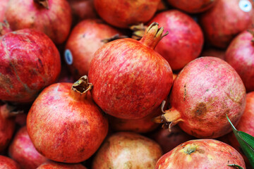 Ripe pomegranate fruits on the counter in the store. Close-up