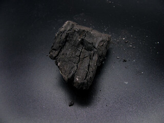 A piece of brown coal on a dark background. A mineral resource.