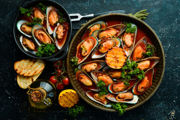 Cooked mussels with tomato sauce, garlic, parsley and lemon. Seafood. Free space for text. On a stone background.