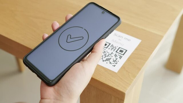Hand's customer scan QR code for online menu service at table in restaurant during pandemic coronavirus. New normal contactless technology lifestyle protection coronavirus pandemic in restaurant