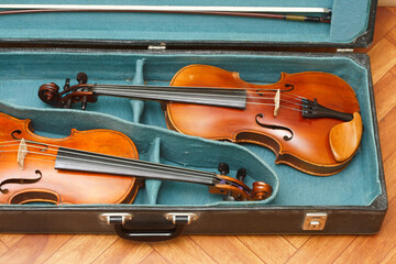 Obraz na płótnie Canvas Two classical violins with bows in a double case 