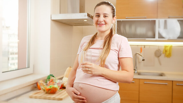 Portrait Of Beautiful Pregnant Woman With Big Belly Waiting For Belly Drinking Fresh Water And Smiling. Concept Of Healthy Lifestyle, Nutrition And Hydration During Pregnancy