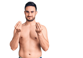 Fototapeta premium Young handsome man wearing swimwear doing money gesture with hands, asking for salary payment, millionaire business