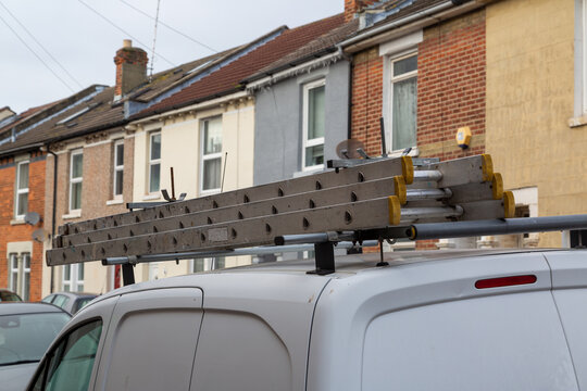 A Set Of Ladders On The Roof Of A Builders Van