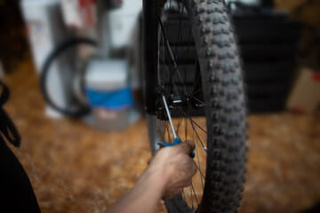 Mechanic fixing front brake of mountain bike in bike shop